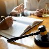 judge-gavel-with-justice-lawyers-having-team-meeti-QX6MZJ2.jpg